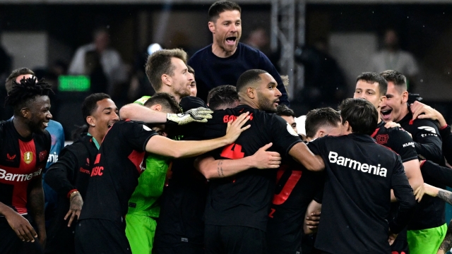 Bayer Leverkusen's Spanish head coach Xabi Alonso (Top Back) and Leverkusen's players celebrate after winning the German Cup (DFB-Pokal) final football match between 1 FC Kaiserslautern and Bayer 04 Leverkusen at the Olympic Stadium in Berlin on May 25, 2024. (Photo by JOHN MACDOUGALL / AFP) / DFB REGULATIONS PROHIBIT ANY USE OF PHOTOGRAPHS AS IMAGE SEQUENCES AND QUASI-VIDEO.