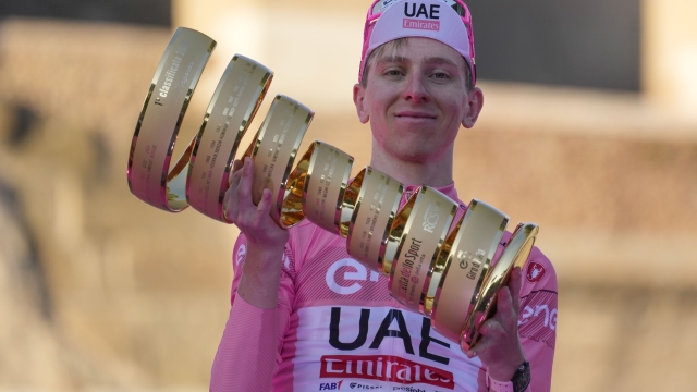 Tour of Italy winner Slovenia's Tadej Pogacar holds the trophy during the podium ceremony at the end of the 21st and last stage of the Giro D'Italia, cycling race, in Rome, Sunday, May 26, 2024. (AP Photo/Andrew Medichini)