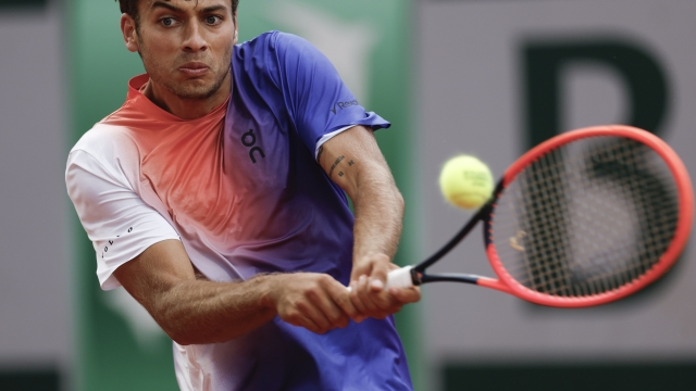 Italy's Flavio Cobolli plays a shot against Denmark's Holger Rune during their second round match of the French Open tennis tournament at the Roland Garros stadium in Paris, Thursday, May 30, 2024. (AP Photo/Jean-Francois Badias)