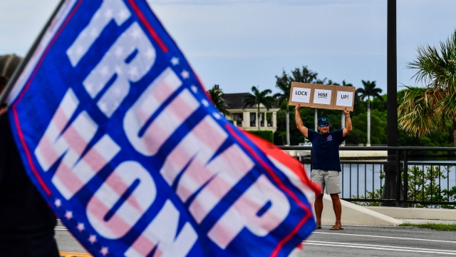 TOPSHOT - A man holds a sign reading "Lock him up" as supporters of former US President and Republican presidential candidate Donald Trump gather near his residence at Mar-a-Lago as they react after he was convicted in his criminal trial, in Palm Beach, Florida, on May 30, 2024. A panel of 12 New Yorkers were unanimous in their determination that Donald Trump is guilty as charged -- but for the impact on his election prospects, the jury is still out. The Republican billionaire was convicted of all 34 charges in New York on May 30, 2024, and now finds himself bidding for a second presidential term unsure if he'll be spending 2025 in the Oval Office, on probation or in jail. (Photo by CHANDAN KHANNA / AFP)