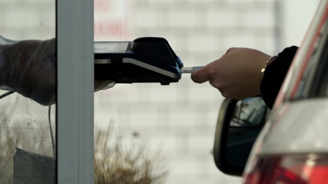 File - A card reader is used at a drive-thru restaurant in Mount Prospect, Ill., March 13, 2021. Noticeable pockets of Americans are quickly running up their credit card balances and increasing numbers are now falling behind on their debts. (AP Photo/Nam Y. Huh, File)
