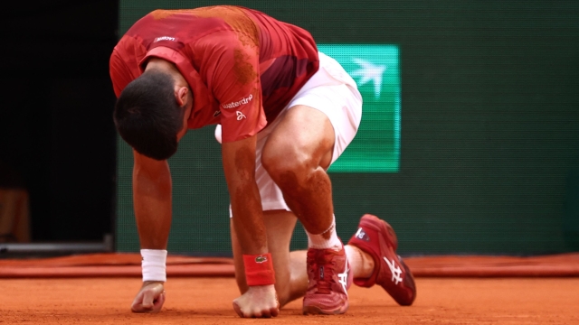 TOPSHOT - Serbia's Novak Djokovic reacts after falling on the court during his men's singles round of sixteen match against Argentina's Francisco Cerundolo on Court Philippe-Chatrier on day nine of the French Open tennis tournament at the Roland Garros Complex in Paris on June 3, 2024. (Photo by Emmanuel Dunand / AFP)
