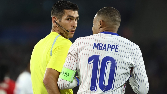 France's forward #10 Kylian Mbappe (R) talks to Portuguese referee Fabio Verissimo (L) during the International friendly football match between France and Canada at the Matmut Atlantique stadium in Bordeaux, on June 9, 2024. (Photo by FRANCK FIFE / AFP)