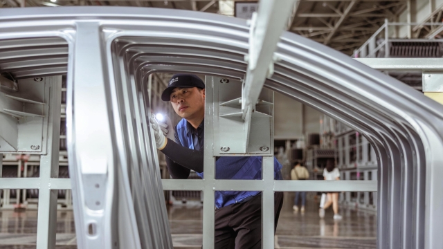 epa10195084 An employee works during an organised media tour to Dongfeng Yueda Kia Factory, in Yancheng, Jiangsu province, China, 20 September 2022. Dongfeng Yueda Kia Factory was put into production in Yancheng, in early 2014, with an annual production capacity of 450,000 vehicles per year. It has a fully automatic production line composed of stamping, welding, painting, final assembly and engine workshops.  EPA/ALEX PLAVEVSKI