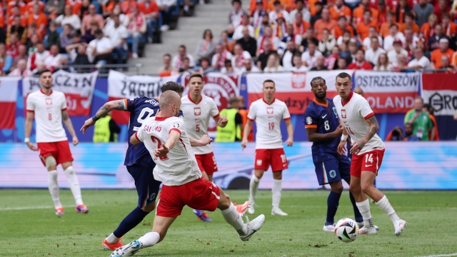 HAMBURG, GERMANY - JUNE 16: Wout Weghorst of the Netherlands scores his team's second goal whilst under pressure from Bartosz Salamon of Poland during the UEFA EURO 2024 group stage match between Poland and Netherlands at Volksparkstadion on June 16, 2024 in Hamburg, Germany.   (Photo by Alex Livesey/Getty Images)