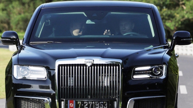 In this pool photograph distributed by the Russian state agency Sputnik, Russian President Vladimir Putin (R) and North Korea's leader Kim Jong Un (L) drive an Aurus car in Pyongyang, on June 19, 2024. Russian President Vladimir Putin signed a mutual defence agreement on June 19 with North Korea's Kim Jong Un, who offered his "full support" on Ukraine. The pledge of military cooperation was part of a strategic treaty signed during a summit in Pyongyang, where Putin was making his first visit in 24 years. (Photo by Gavriil GRIGOROV / POOL / AFP) / -- Editor's note : this image is distributed by the Russian state owned agency Sputnik -