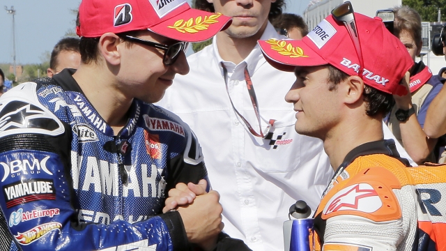 Honda rider Dani Pedrosa, of Spain, right, is congratulated by Yamaha rider Jorge Lorenzo, of Spain, after clocking the fastest time during a qualifying practice session of the San Marino MotoGP grand prix at the Misano circuit, in Misano Adriatico, Italy, Saturday, Sept. 15, 2012. Lorenzo set the second fastest time. (AP Photo/Antonio Calanni)