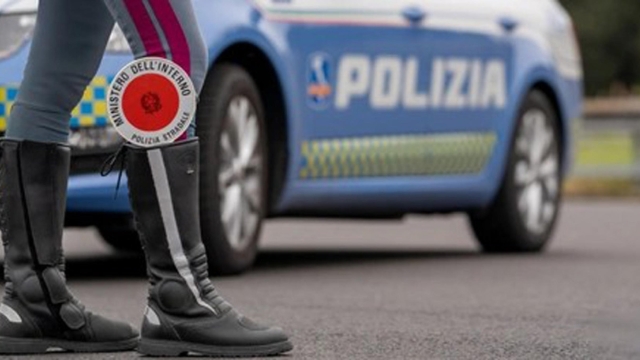 Dettaglio degli stivali di un poliziotto con la paletta infilata dentro, davanti ad una volante della polizia, durante un controllo in strada, in una foto d'archivio. ANSA / POLIZIA DI STATO  (simbolica, generica, controlli, polizia, sicurezza, strada)