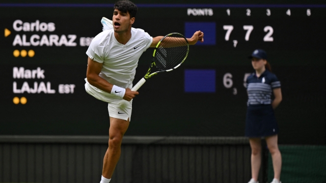 Spain's Carlos Alcaraz serves against Estonia's Mark Lajal during their men's singles tennis match on the first day of the 2024 Wimbledon Championships at The All England Lawn Tennis and Croquet Club in Wimbledon, southwest London, on July 1, 2024. (Photo by Glyn KIRK / AFP) / RESTRICTED TO EDITORIAL USE