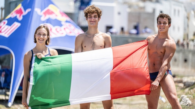 Italian divers (L-R) Elisa Cosetti, Andrea Barnaba and Davide Baraldi pose with their national flag during the training day of the third stop of the Red Bull Cliff Diving World Series in Polignano a Mare, Italy on June 30, 2023. // Dean Treml / Red Bull Content Pool // SI202307080409 // Usage for editorial use only //