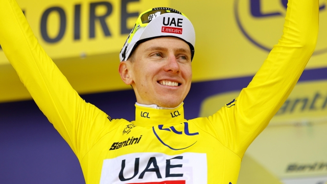 epa11452679 Slovenian rider Tadej Pogacar of UAE Team Emirates celebrates in the overall leader's yellow jersey on the podium after winning the fourth stage of the 2024 Tour de France cycling race over 139km from Pinerolo to Valloire, France, 02 July 2024.  EPA/KIM LUDBROOK