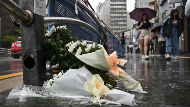 Flowers are seen placed at the site of a car accident, which left at least nine people dead, in Seoul on July 2, 2024. At least nine people were killed and four others were injured when a car struck pedestrians near Seoul city hall on July 1, police said. (Photo by Jung Yeon-je / AFP)
