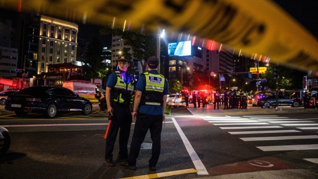 Police stand near the site of a car accident, which left at least nine people dead, in Seoul late on July 1, 2024. At least nine people were killed and four others were injured when a car struck pedestrians near Seoul city hall on July 1, police said. (Photo by ANTHONY WALLACE / AFP)
