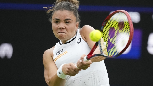 Jasmine Paolini of Italy plays a backhand return toGreet Minnen of Belgium during their match on day three at the Wimbledon tennis championships in London, Wednesday, July 3, 2024. (AP Photo/Mosa'ab Elshamy)