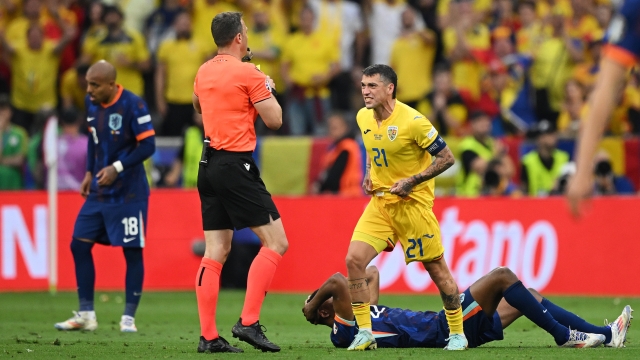 MUNICH, GERMANY - JULY 02: Nicolae Stanciu of Romania reacts before he is shown a yellow card by Referee Felix Zwayer during the UEFA EURO 2024 round of 16 match between Romania and Netherlands at Munich Football Arena on July 02, 2024 in Munich, Germany. (Photo by Clive Mason/Getty Images)