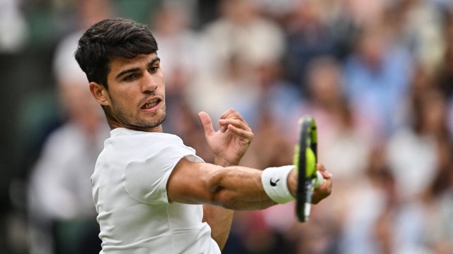 Spain's Carlos Alcaraz returns the ball to US player Frances Tiafoe during their men's singles tennis match on the fifth day of the 2024 Wimbledon Championships at The All England Lawn Tennis and Croquet Club in Wimbledon, southwest London, on July 5, 2024. (Photo by Glyn KIRK / AFP) / RESTRICTED TO EDITORIAL USE