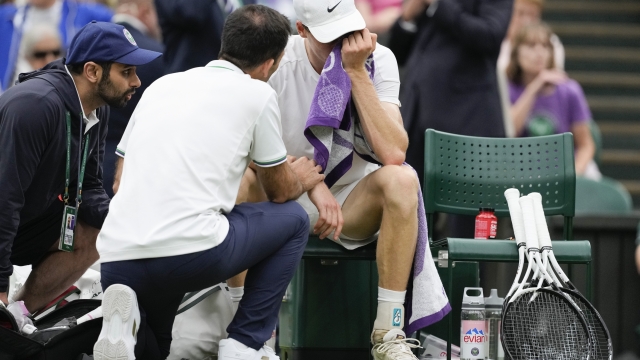 Jannik Sinner of Italy reacts as he receives treatment from a trainer during his quarterfinal match against Daniil Medvedev of Russia at the Wimbledon tennis championships in London, Tuesday, July 9, 2024. (AP Photo/Alberto Pezzali)