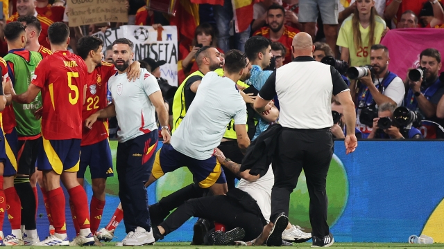 MUNICH, GERMANY - JULY 09: A Member of Security slides into Alvaro Morata of Spain as he attempts to remove a Pitch Invader as players of Spain celebrate after the UEFA EURO 2024 Semi-Final match between Spain and France at Munich Football Arena on July 09, 2024 in Munich, Germany. (Photo by Alex Grimm/Getty Images)