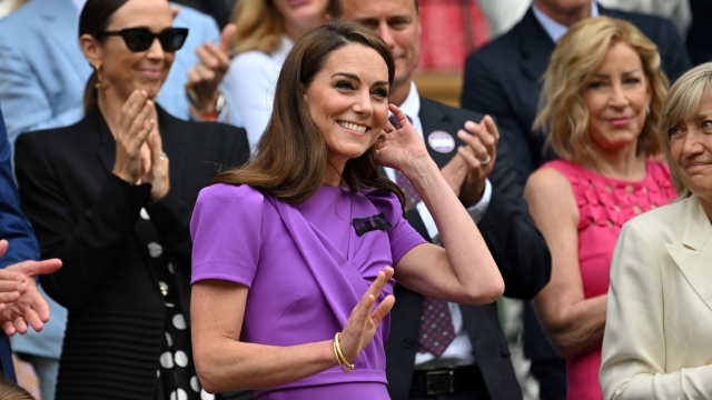 TOPSHOT - Britain's Catherine, Princess of Wales (C) waves as she arrives in the Royal Box on Centre Court to attend the men's singles final tennis match on the fourteenth day of the 2024 Wimbledon Championships at The All England Lawn Tennis and Croquet Club in Wimbledon, southwest London, on July 14, 2024. (Photo by ANDREJ ISAKOVIC / AFP) / RESTRICTED TO EDITORIAL USE