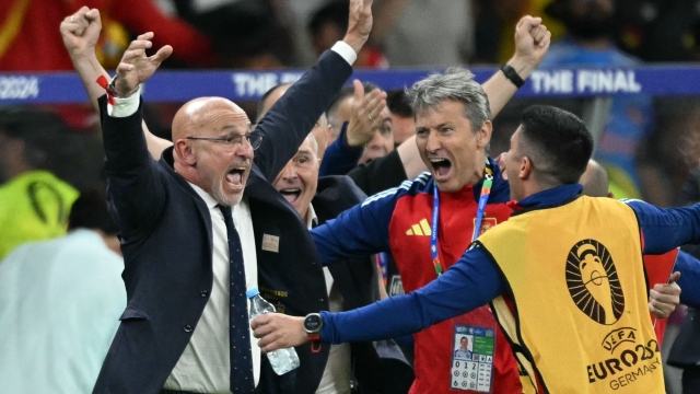 Spain's head coach Luis de la Fuente (L) celebrates with his assistants after winning at the end of the UEFA Euro 2024 final football match between Spain and England at the Olympiastadion in Berlin on July 14, 2024. (Photo by INA FASSBENDER / AFP)
