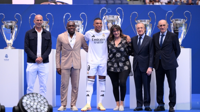 MADRID, SPAIN - JULY 16: Real Madrid new signing, Kylian Mbappe (3L) poses for a photo with former Real Madrid player and coach, Zinedine Zidane (L), former Real Madrid player, Pirri (R) and President of Real Madrid, Florentino Perez Rodriguez (2R) and his parents, father, Wilfried Mbappe (2L) and mother, Fayza Lamari (3R) as he is unveiled at Estadio Santiago Bernabeu on July 16, 2024 in Madrid, Spain. (Photo by David Ramos/Getty Images)