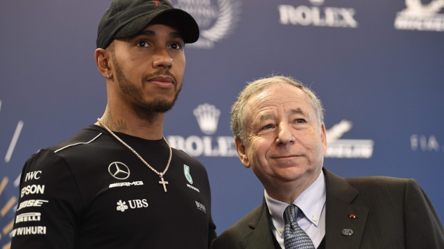 World's Formula One British driver Lewis Hamilton (L) poses next to the President of the FIA (International Automobile Federation) Jean Todt during a press conference in Paris on December 8, 2017. 
 / AFP PHOTO / CHRISTOPHE SIMON