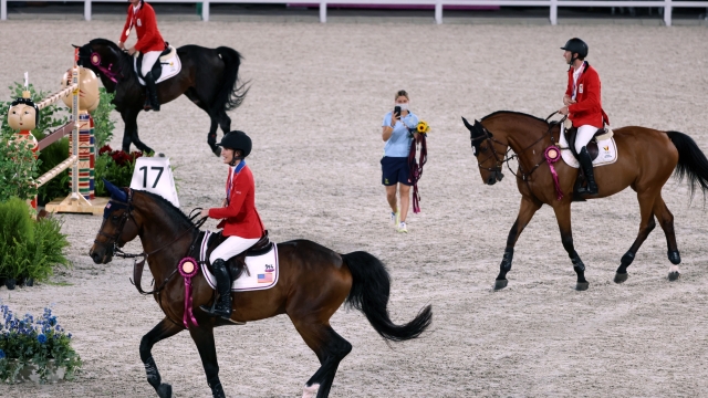 Bronze medalists Belgium Gregory Wathelet (L), Pieter Devos (R) and US Jessica Springsteen (C) parade after the medal ceremony of the equestrian's jumping team during the Tokyo 2020 Olympic Games at the Equestrian Park in Tokyo on August 7, 2021. (Photo by Behrouz MEHRI / AFP)