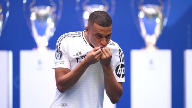 MADRID, SPAIN - JULY 16: Real Madrid new signing, Kylian Mbappe kisses the Real Madrid badge as he is unveiled at Estadio Santiago Bernabeu on July 16, 2024 in Madrid, Spain. (Photo by David Ramos/Getty Images)