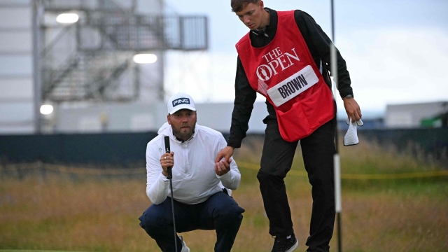 England's Daniel Brown and his caddie on the 16th green on the opening day of the 152nd British Open Golf Championship at Royal Troon on the south west coast of Scotland on July 18, 2024. (Photo by ANDY BUCHANAN / AFP) / RESTRICTED TO EDITORIAL USE