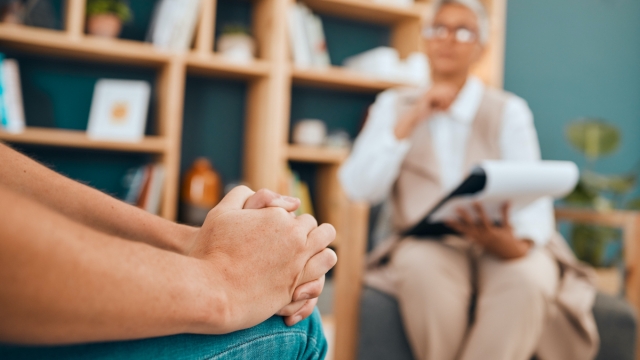 Hands, psychology and patient with anxiety in a session for help or mental health counseling. Healthcare, psychiatry and closeup of a woman with depression, trauma or stress speaking to psychologist.