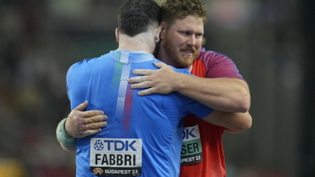 Ryan Crouser, of the United States, right who won the gold medal in the Men's-shot put final hugs Leonardo Fabbri, of Italy, who won the silver after the end of the competition during the World Athletics Championships in Budapest, Hungary, Saturday, Aug. 19, 2023. (AP Photo/Ashley Landis)