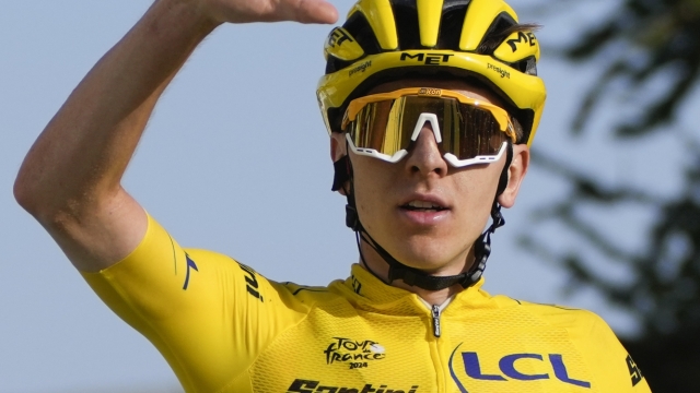 Slovenia's Tadej Pogacar, wearing the overall leader's yellow jersey, flashes five fingers for his fifth stage victory as he crosses the finish line to win the twentieth stage of the Tour de France cycling race over 132.8 kilometers (82.5 miles) with start in Nice and finish in La Couillole pass, France, Saturday, July 20, 2024. (AP Photo/Jerome Delay)