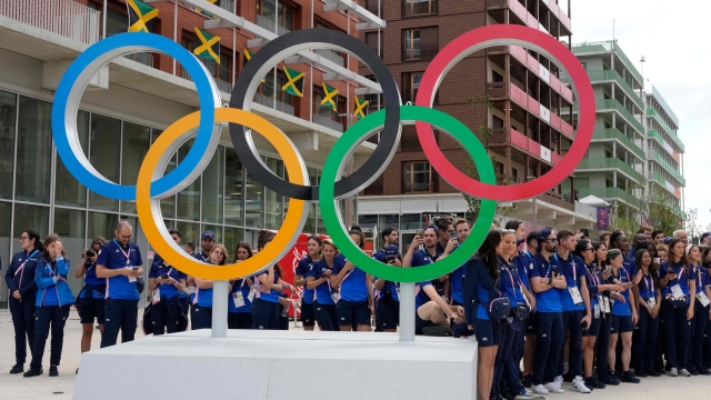 French athletes gather behind the Olympic Rings at the Olympic Village, in Saint-Denis, northern Paris, on July 22, 2024, ahead of the opening ceremony of Paris 2024 Olympic and Paralympic Games. (Photo by Michel Euler / POOL / AFP)