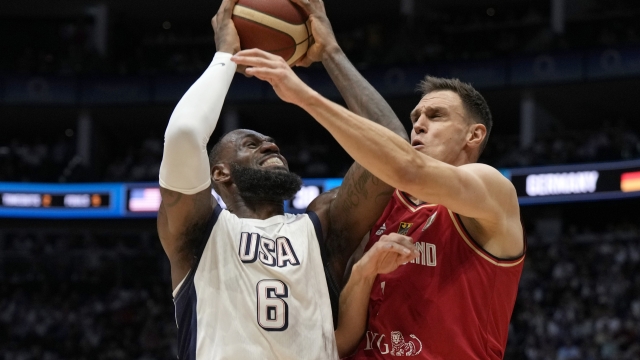 Germany's Johannes Voigtmann, right, blocks United States' forward LeBron James during an exhibition basketball game between the United States and Germany at the O2 Arena in London, Monday, July 22, 2024. (AP Photo/Alastair Grant)