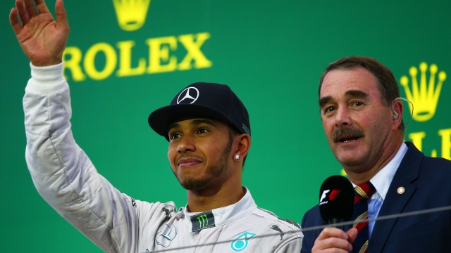 SUZUKA, JAPAN - OCTOBER 05: Lewis Hamilton of Great Britain and Mercedes GP celebrates following his victory alongside compere Nigel Mansell during the Japanese Formula One Grand Prix at Suzuka Circuit on October 5, 2014 in Suzuka, Japan. (Photo by Clive Mason/Getty Images)
