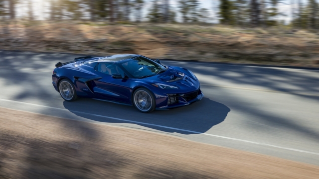 Passenger side view of Chevrolet Corvette ZR1 Convertible in Hysteria Purple driving down a mountain road. Preproduction model shown. Actual production model may vary.