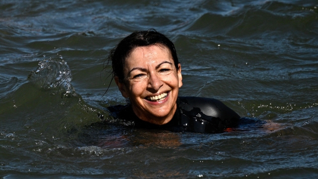 Paris Mayor Anne Hidalgo swims in the Seine, in Paris on July 17, 2024, to demonstrate that the river is clean enough to host the outdoor swimming events at the Paris Olympics later this month. Despite an investment of 1.4 billion euros ($1.5 billion) to prevent sewage leaks into the waterway, the Seine has been causing suspense in the run-up to the opening of the Paris Games on July 26 after repeatedly failing water quality tests. But since the beginning of July, with heavy rains finally giving way to sunnier weather, samples have shown the river to be ready for the open-water swimming and triathlon -- and for 65-year-old Hidalgo. (Photo by JULIEN DE ROSA / AFP)