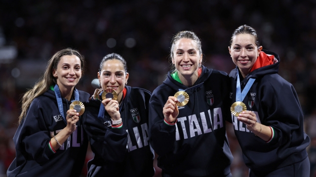 Gold medallists Italy's Rossella Fiamingo (L), Italy's Alberta Santuccio, Italy's Giulia Rizzi and Italy's Mara Navarria celebrate on the podium during the medal ceremony for the women's epee team competition during the Paris 2024 Olympic Games at the Grand Palais in Paris, on July 30, 2024. (Photo by Franck FIFE / AFP)