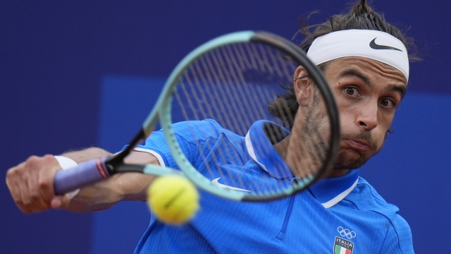 Lorenzo Musetti of Italy returns a backhand shot to Alexander Zverev of Germany during their men's singles quarterfinals match, at the 2024 Summer Olympics, Thursday, Aug.1, 2024, at the Roland Garros stadium in Paris, France. (AP Photo/Andy Wong)