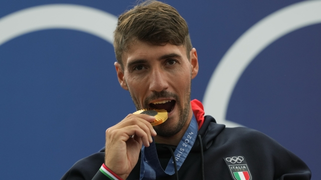 Gold medalist Giovanni de Gennaro of Italy poses during a medals ceremony for the men's kayak single finals at the 2024 Summer Olympics, Thursday, Aug. 1, 2024, in Vaires-sur-Marne, France. (AP Photo/Kirsty Wigglesworth)