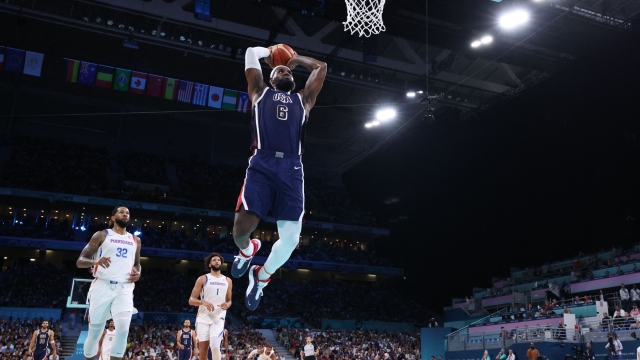 TOPSHOT - USA's #06 LeBron James dunks the ball in the men's preliminary round group C basketball match between Puerto Rico and USA during the Paris 2024 Olympic Games at the Pierre-Mauroy stadium in Villeneuve-d'Ascq, northern France, on August 3, 2024. (Photo by Thomas COEX / AFP)