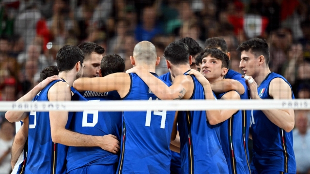 Italy's players celebrate after the men's preliminary round volleyball match between Poland and Italy during the Paris 2024 Olympic Games at the South Paris Arena 1 in Paris on August 3, 2024. Italy won the match 3-1. (Photo by Natalia KOLESNIKOVA / AFP)