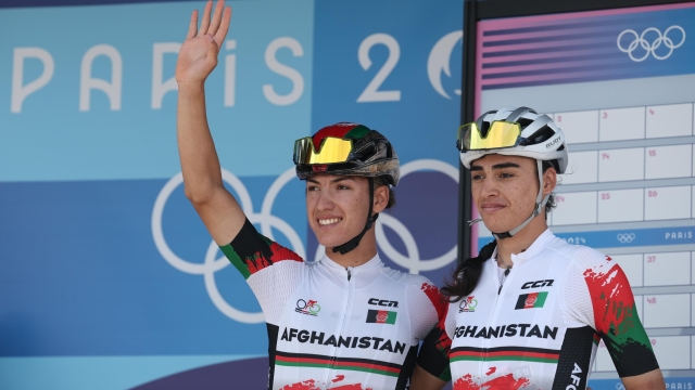 epa11524886 Fariba Hashimi (L) and Yulduz Hashimi of Afghanistan at the presentation of the riders prior to the departure of the Women's Road Cycling Race of the Paris 2024 Olympic Games in Paris, France, 04 August 2024.  EPA/CHRISTOPHE PETIT TESSON