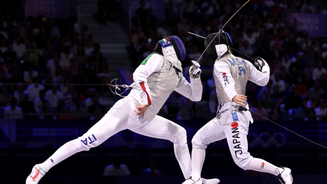 PARIS, FRANCE - AUGUST 04: Filippo Macchi of Team Italy competes against Kazuki Iimura of Team Japan during the Fencing Men's Foil Gold Medal match between Team Italy and Team Japan on day nine of the Olympic Games Paris 2024 at Grand Palais on August 04, 2024 in Paris, France. (Photo by Ezra Shaw/Getty Images)