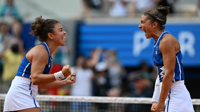 TOPSHOT - Italy's Sara Errani (R) and Italy's Jasmine Paolini (L) react to beating Individual Neutral Athlete Mirra Andreeva and Individual Neutral Athlete Diana Shnaider during their women's doubles final tennis match on Court Philippe-Chatrier at the Roland-Garros Stadium during the Paris 2024 Olympic Games, in Paris on August 4, 2024. (Photo by Patricia DE MELO MOREIRA / AFP)