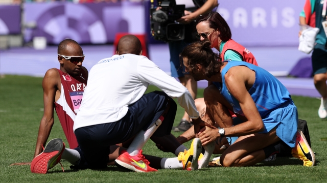 PARIS, FRANCE - AUGUST 07: Gianmarco Tamberi of Team Italy checks the conditions of Mutaz Essa Barshim of Team Qatar during the Men's High Jump Qualification on day twelve of the Olympic Games Paris 2024 at Stade de France on August 07, 2024 in Paris, France. (Photo by Cameron Spencer/Getty Images)