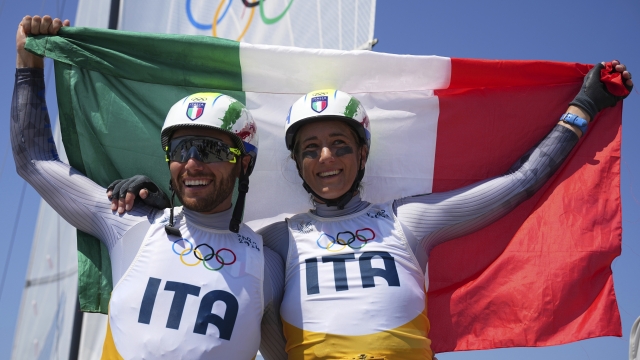 Ruggero Tita and Caterina Banti of Italy celebrate after the Nacra 17 mixed multihull medal race during the 2024 Summer Olympics, Thursday, Aug. 8, 2024, in Marseille, France. (AP Photo/Daniel Cole)