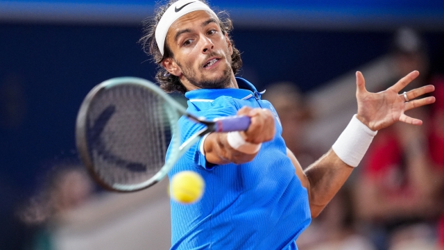 Lorenzo Musetti of Italy returns the ball against Felix Auger-Aliassime of Canada during men's singles bronze medal tennis match at the Roland Garros stadium, at the 2024 Summer Olympics, Saturday, Aug. 3, 2024, in Paris, France. (AP Photo/Manu Fernandez)