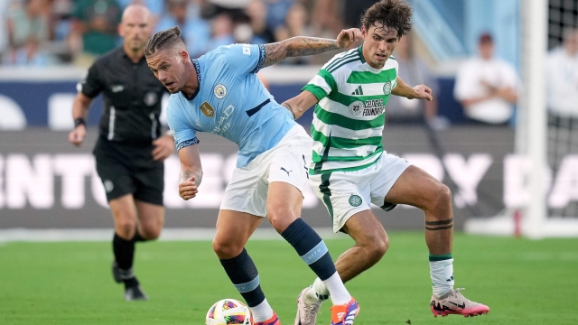 CHAPEL HILL, NORTH CAROLINA - JULY 23: Kalvin Phillips #4 of Manchester City challenges Matt O'Riley #33 of Celtic during the pre-season friendly match at Kenan Stadium on July 23, 2024 in Chapel Hill, North Carolina.   Grant Halverson/Getty Images/AFP (Photo by GRANT HALVERSON / GETTY IMAGES NORTH AMERICA / Getty Images via AFP)