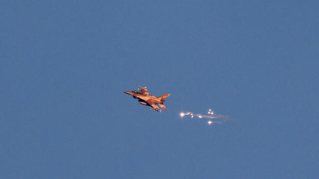 This photo taken from a position in northern Israel shows an Israeli Air Force fighter jet firing flares as it flies to intercept a hostile aircraft that launched from Lebanon over the border area with south Lebanon on August 25, 2024. The Israeli military announced early August 25, 2024 that it was conducting pre-emptive strikes in Lebanon after detecting preparations for "large-scale" attacks by the Iran-backed militant group Hezbollah. Hezbollah said August 25, 2024 it had launched more than 320 rockets at Israel overnight, targeting a string of military positions, even as Israel's military said it was carrying out pre-emptive strikes against the group. (Photo by Jalaa MAREY / AFP)